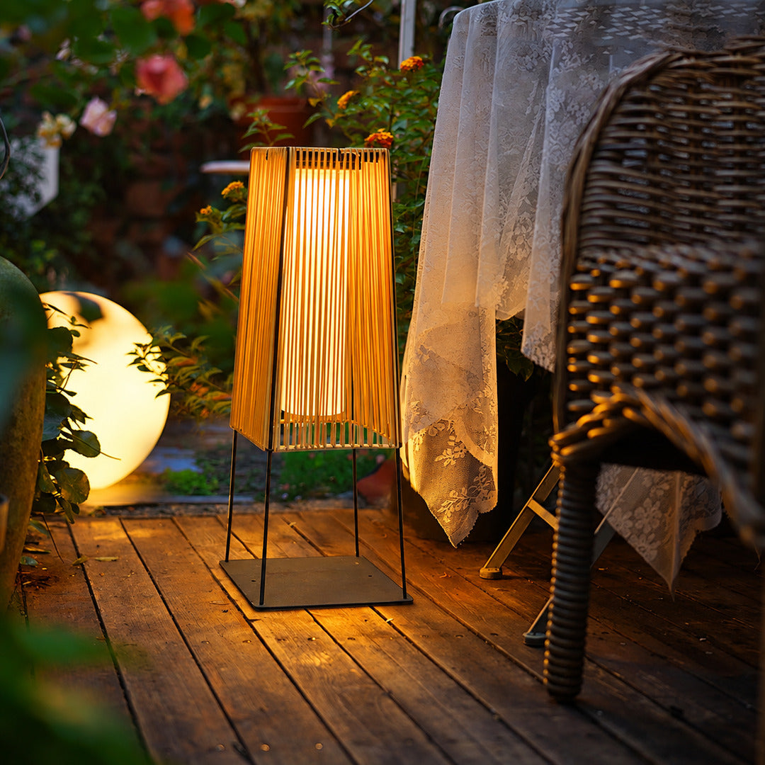 Intreccio outdoor post lights lining a garden bed with a warm woven glow at dusk