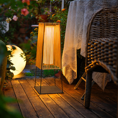 Intreccio outdoor post lights lining a garden bed with a warm woven glow at dusk