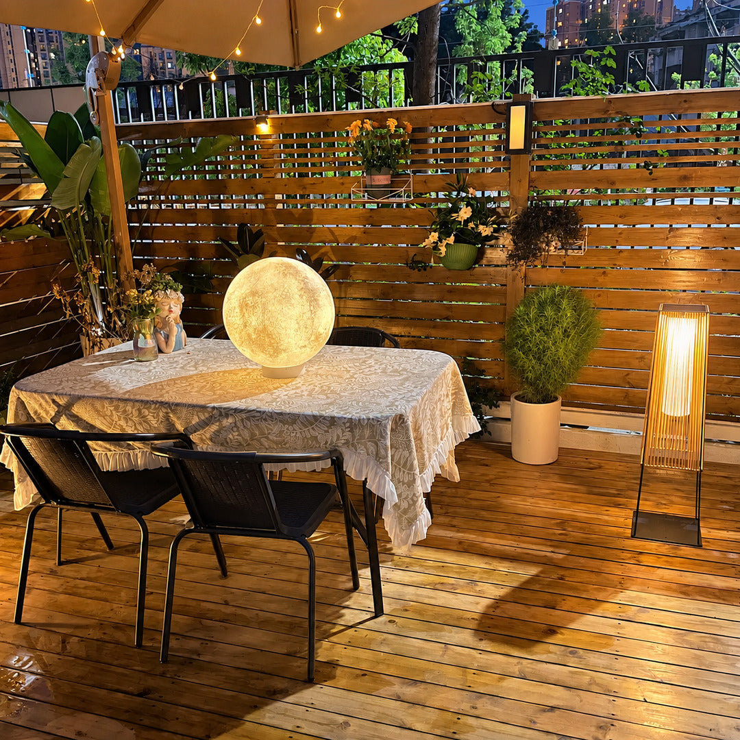 Tall Intreccio outdoor post light standing as a floor lantern on a backyard deck
