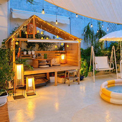 Tall Intreccio outdoor post light standing as a floor lantern on a backyard deck