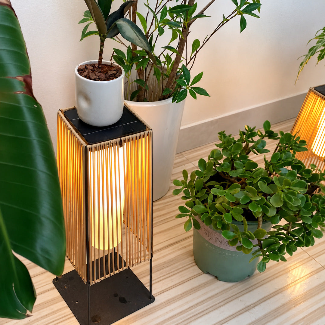 Intreccio outdoor post lights lining a garden bed with a warm woven glow at dusk
