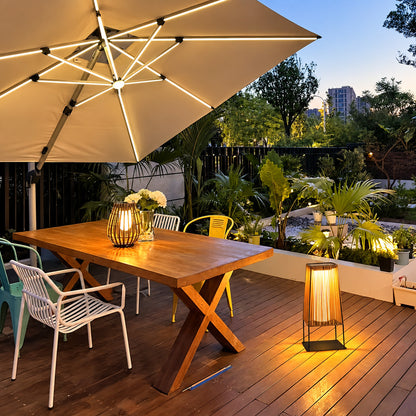 Intreccio outdoor post lights lining a garden bed with a warm woven glow at dusk
