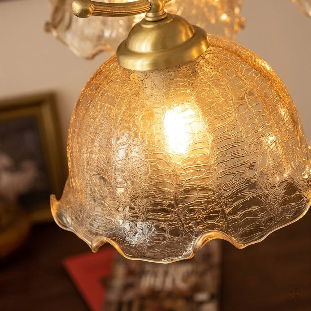 Iris rippled glass shade close up illuminated warm amber glow Edison filament bulb visible refraction texture detail