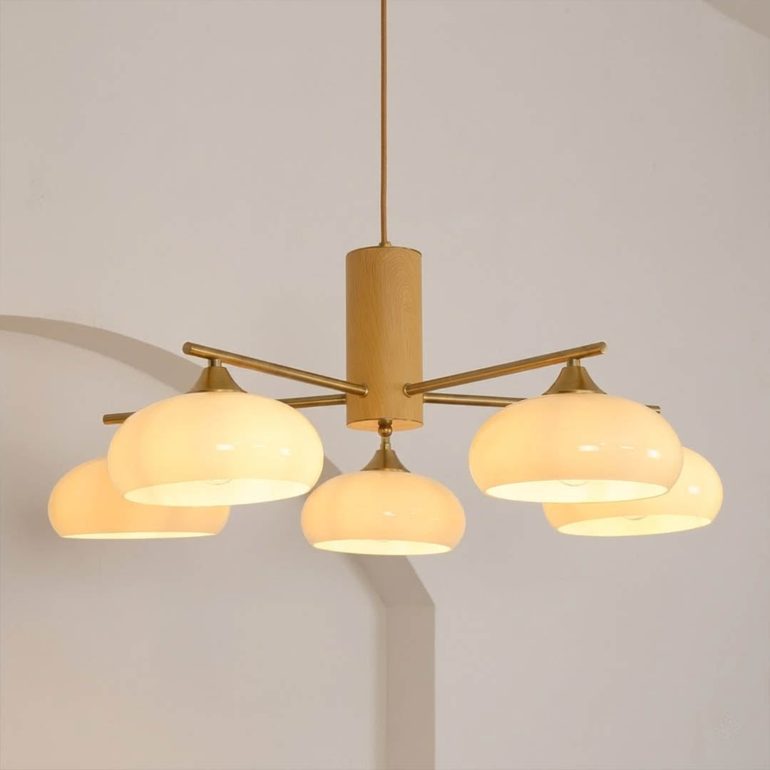 Juno brass chandelier above dining table warm glow glass shades elegant interior