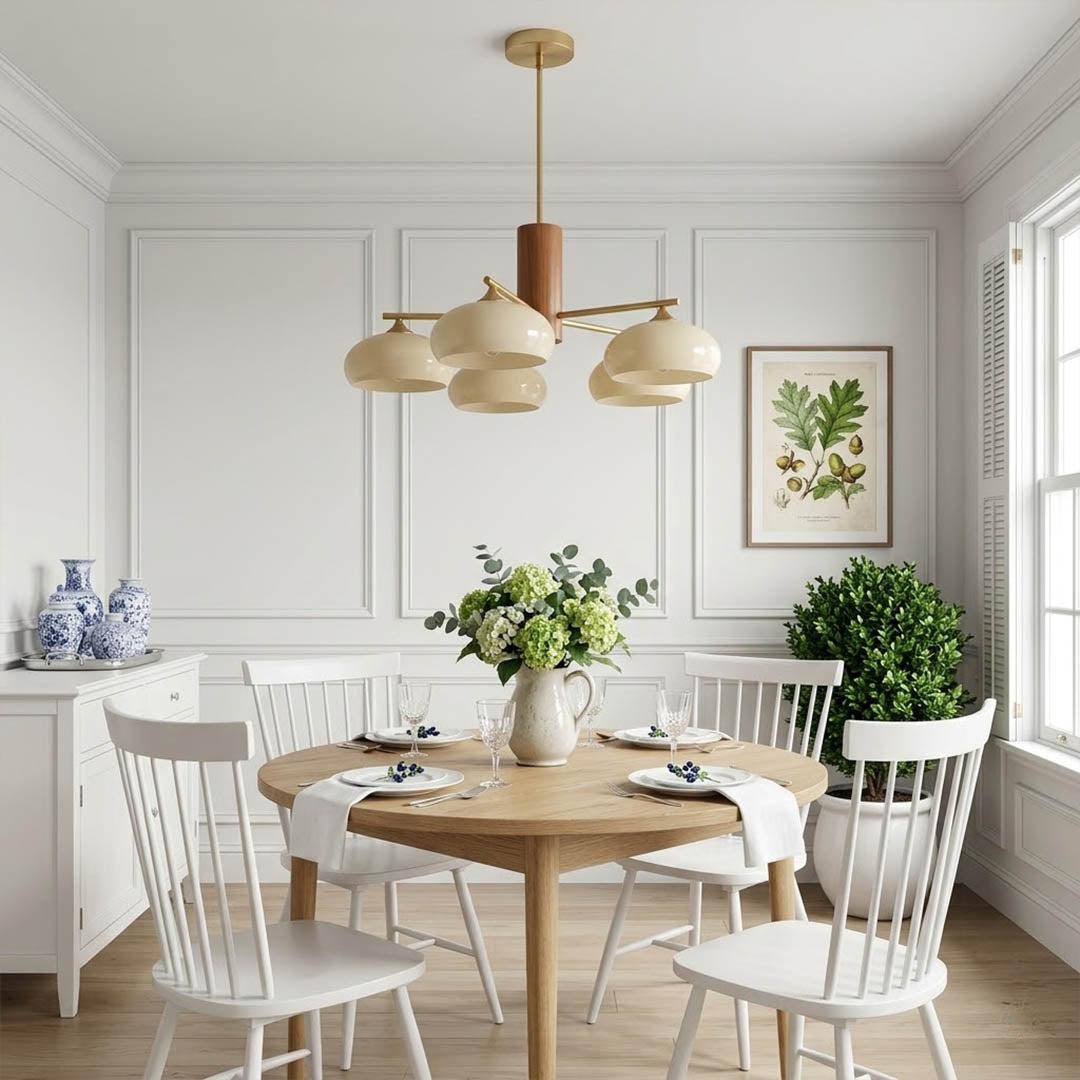 Juno brass chandelier above dining table warm glow glass shades elegant interior