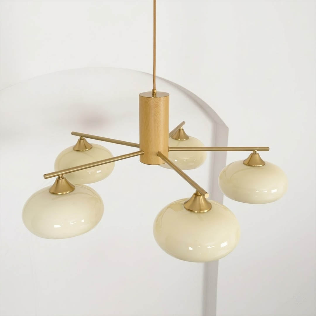 Juno brass chandelier above dining table warm glow glass shades elegant interior