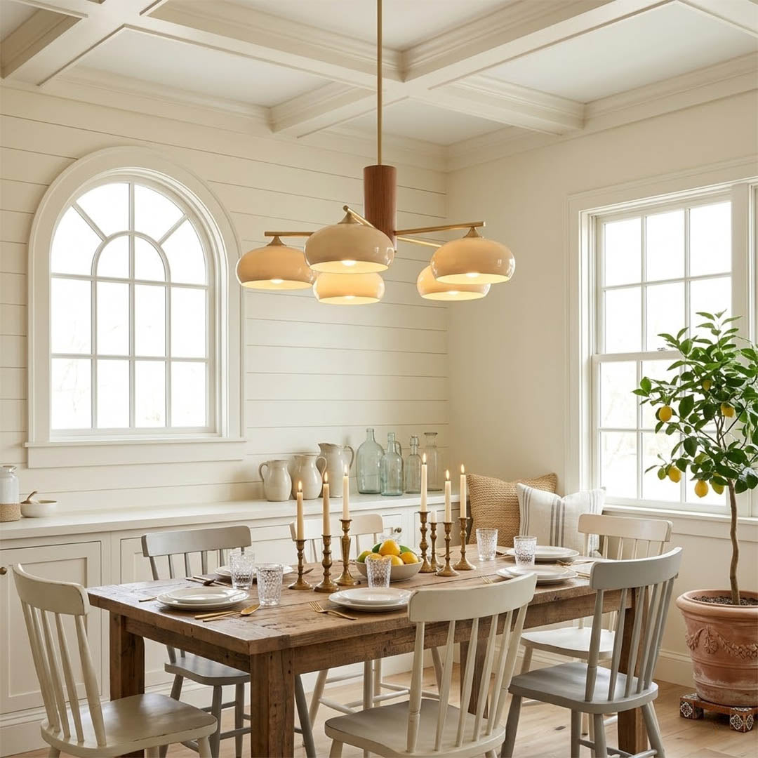 Juno brass chandelier above dining table warm glow glass shades elegant interior