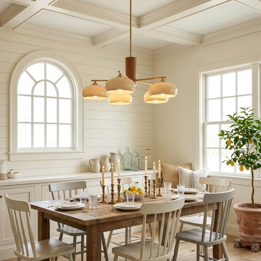 Juno brass chandelier above dining table warm glow glass shades elegant interior