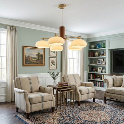 Juno brass chandelier above dining table warm glow glass shades elegant interior