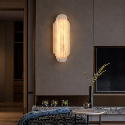 Lamina alabaster wall sconce adding a soft glow to a living room wall