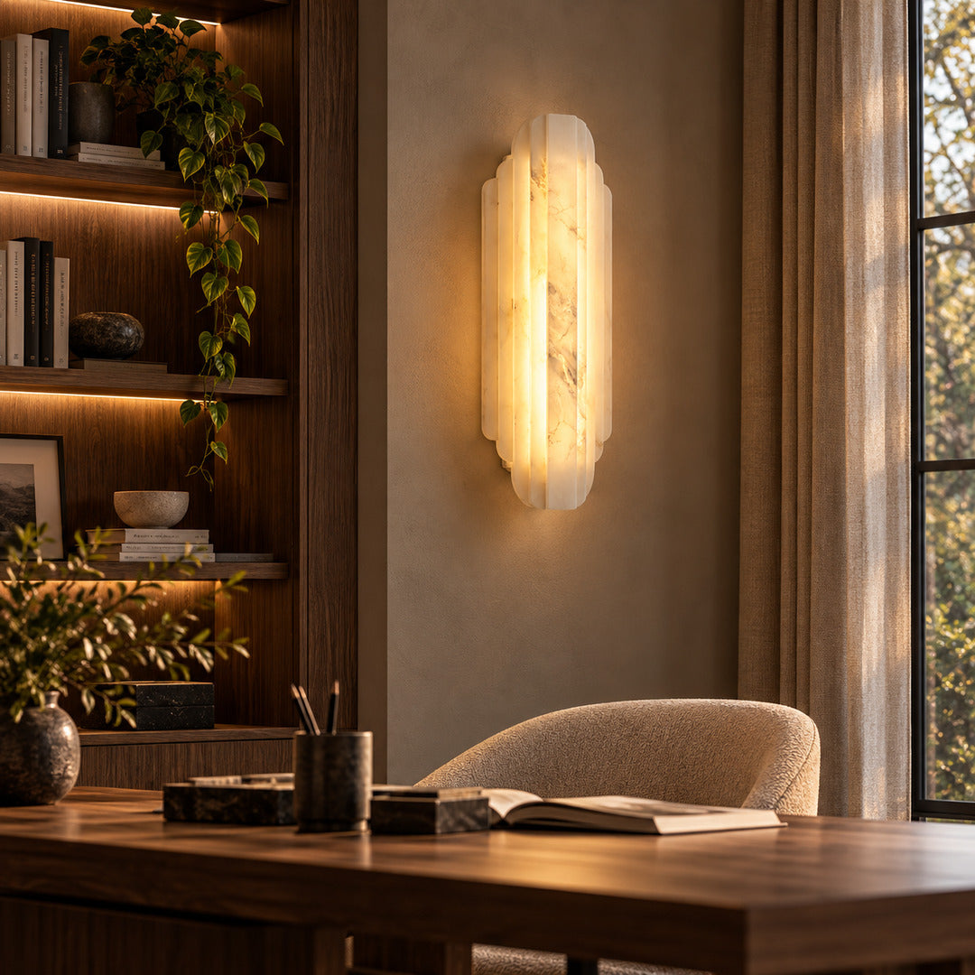 Lamina alabaster wall sconce on a home study wall beside a bookshelf