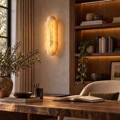 Lamina alabaster wall sconce on a home study wall beside a bookshelf