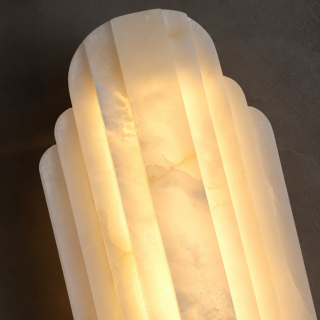 Close-up of natural veining glowing through the layered alabaster discs of the Lamina wall sconce