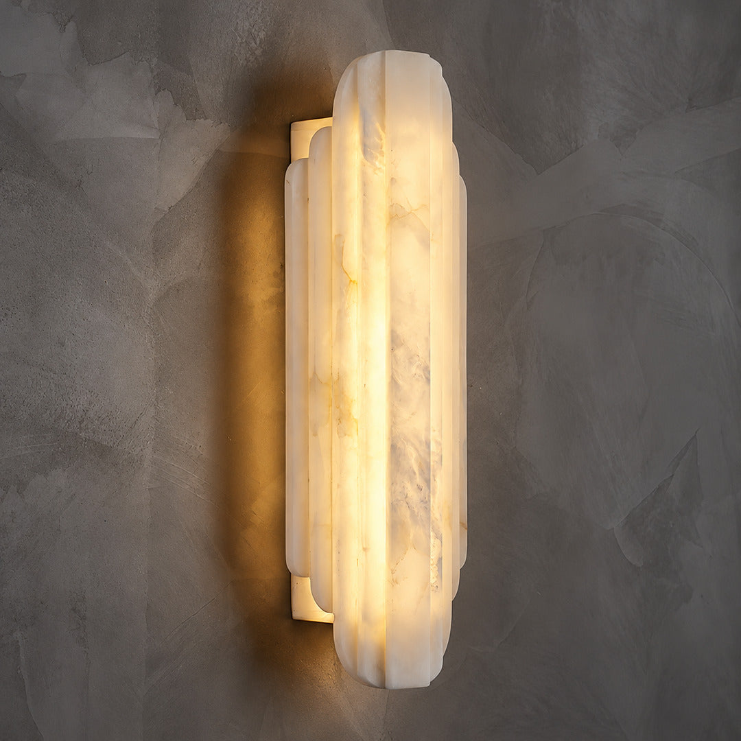 Close-up of natural veining glowing through the layered alabaster discs of the Lamina wall sconce