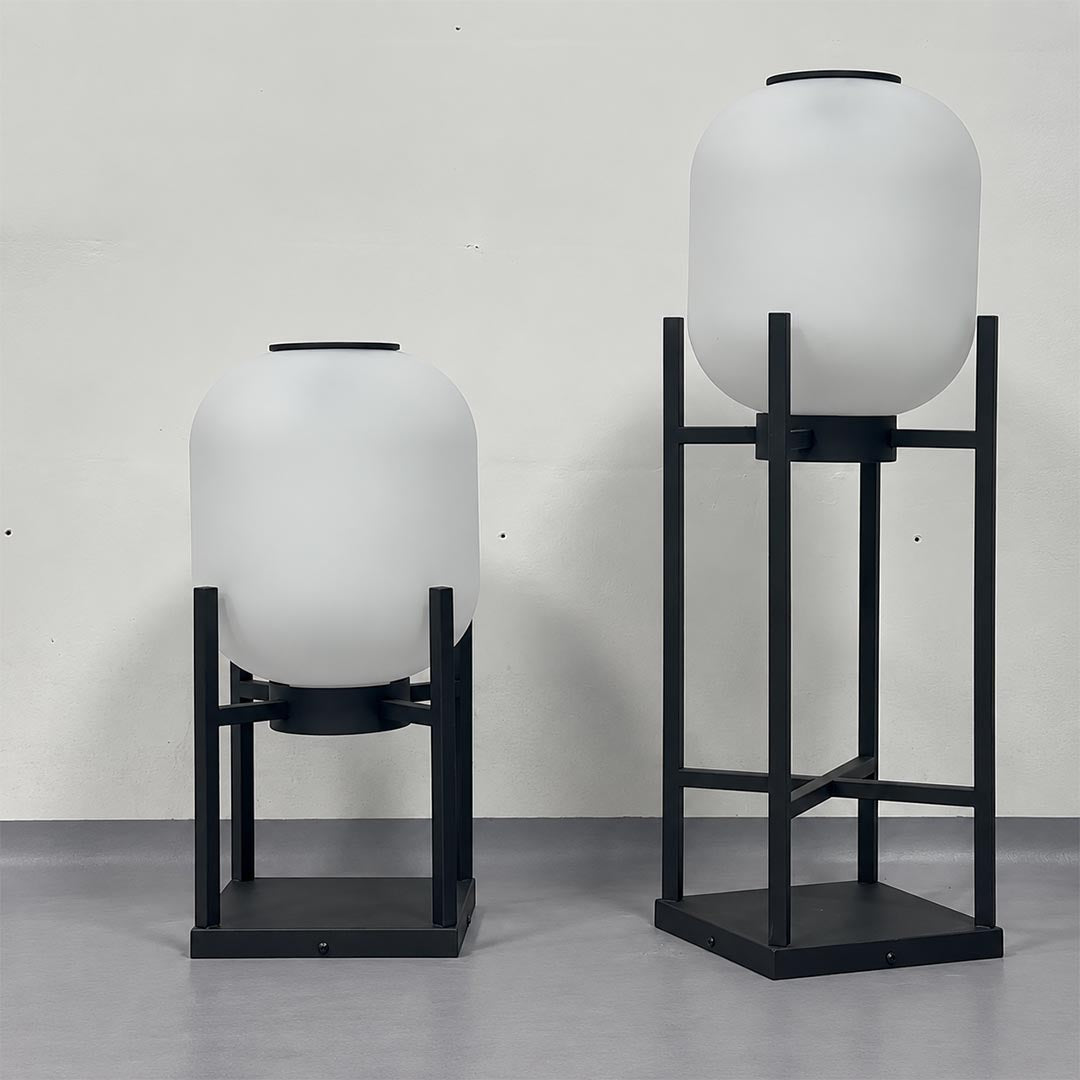 Short and tall Larsen solar powered outdoor lantern floor lamps unlit with white frosted shades.