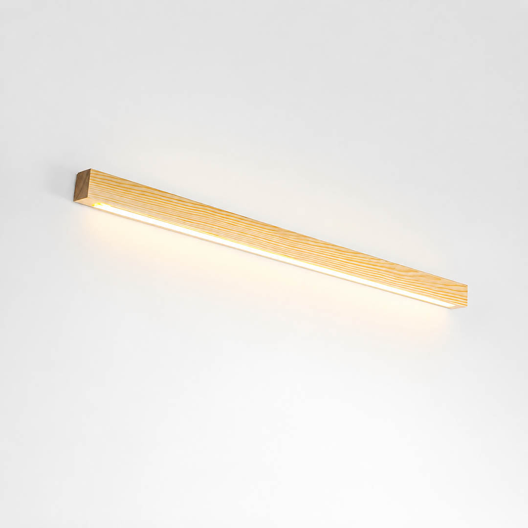 Larsson linear wood wall light natural pine wood color integrated LED warm glow slim bar white background front view