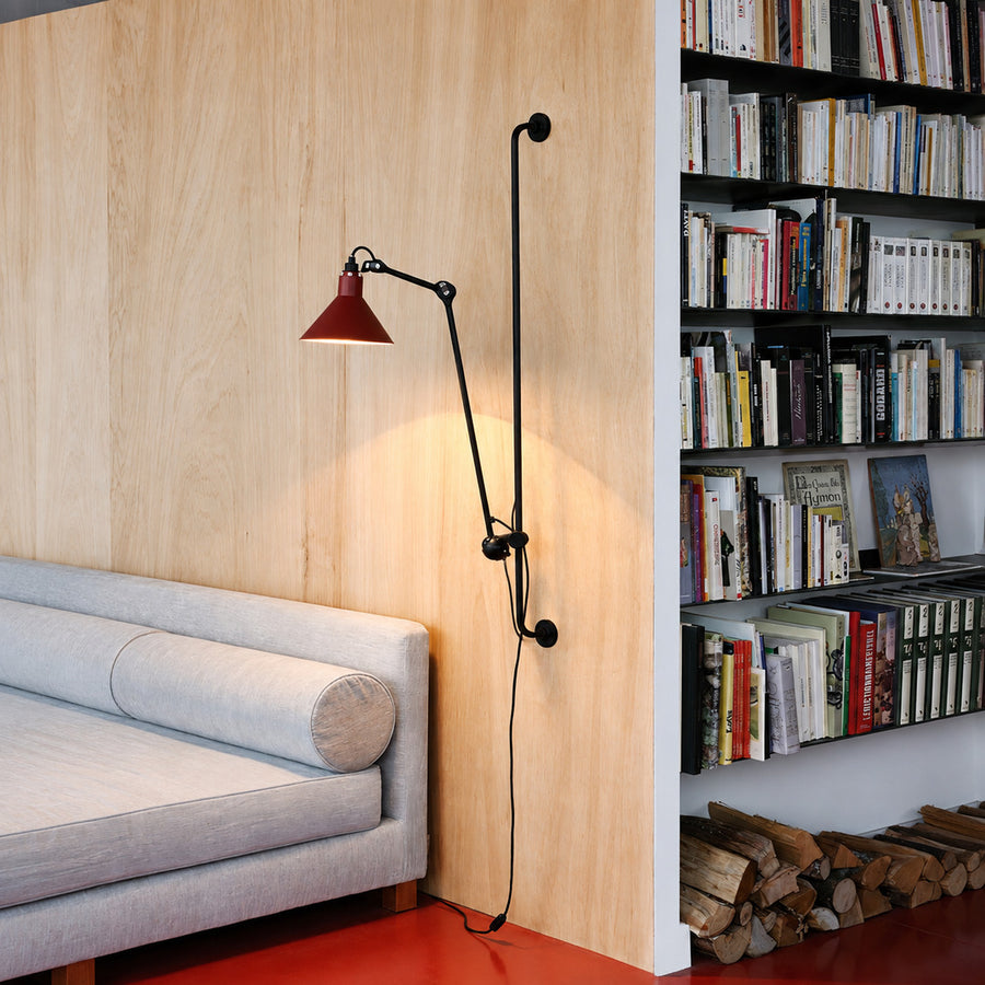 Leva swing arm wall sconce extended over a pillow as a space-saving bedside reading light