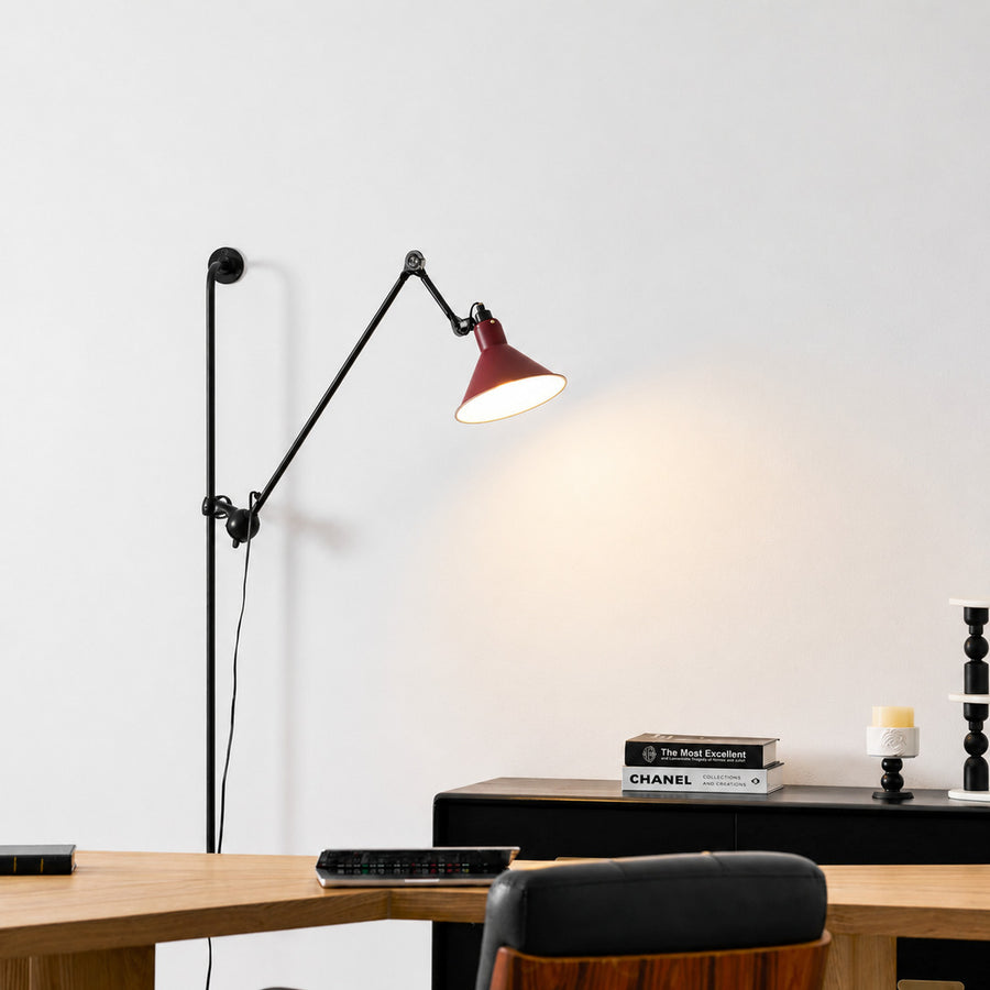 Leva swing arm wall sconce angled over an armchair in a cozy corner reading nook