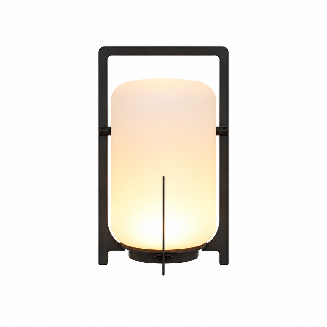 Lucciola rechargeable lantern with a warm glow standing cordless on an outdoor patio table