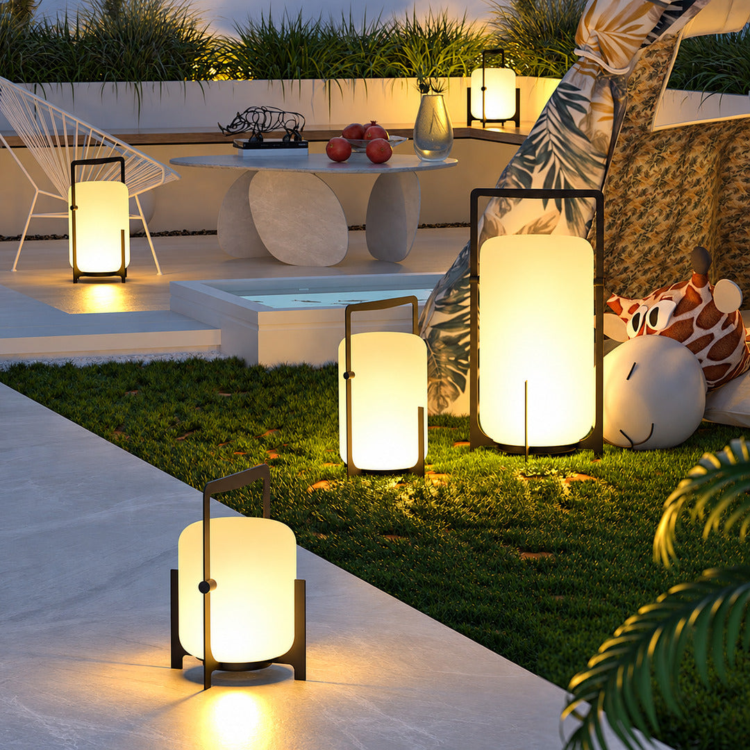 Lucciola rechargeable lantern glowing warmly on a patio dining table at dusk