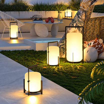 Lucciola rechargeable lantern glowing warmly on a patio dining table at dusk