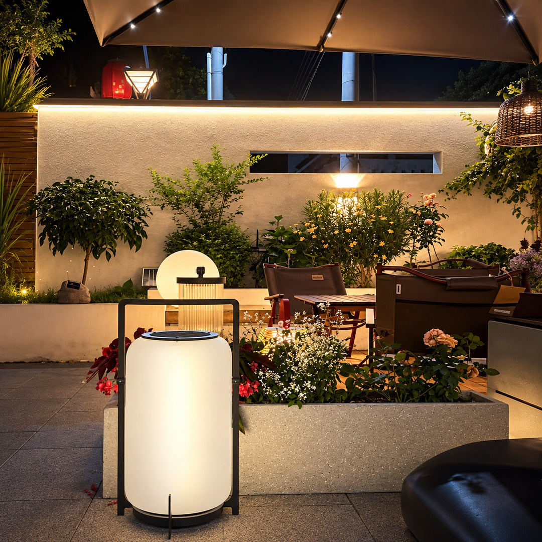 Lucciola rechargeable lantern lighting a garden seating area with a soft warm glow