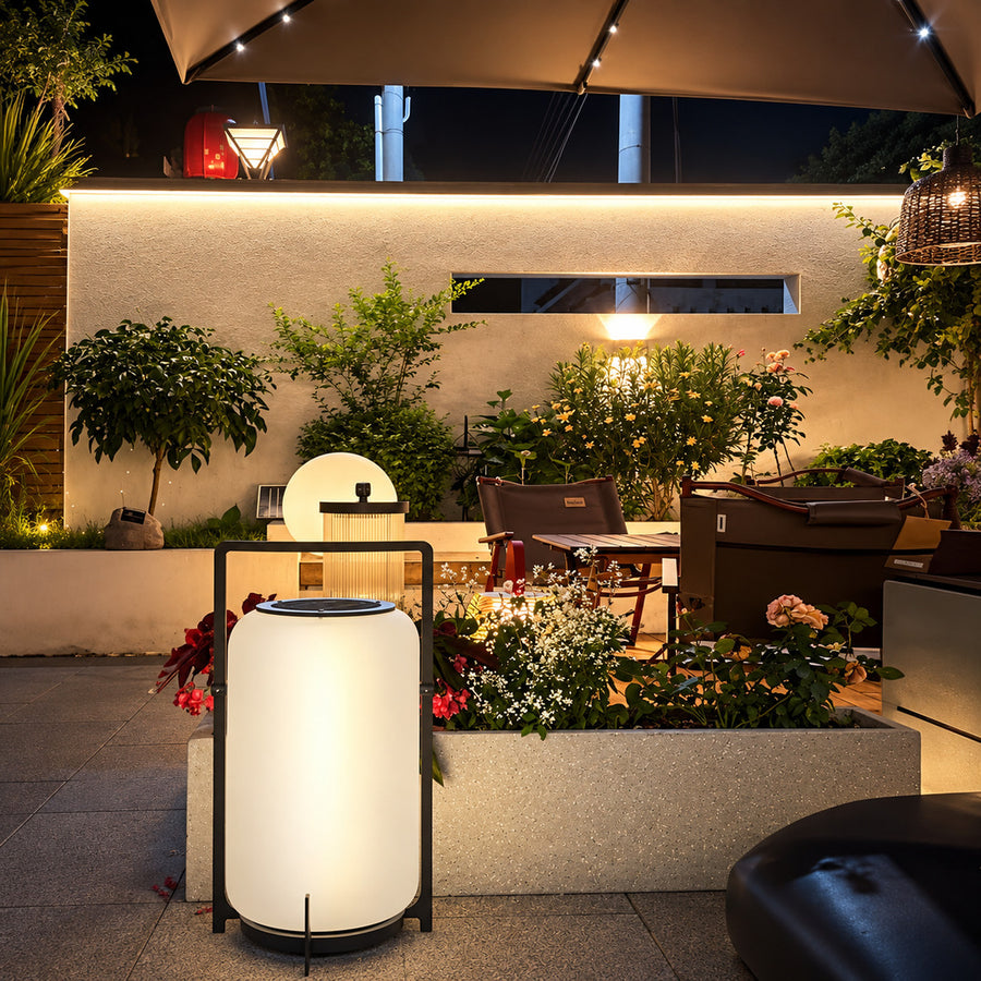 Lucciola rechargeable lantern lighting a garden seating area with a soft warm glow
