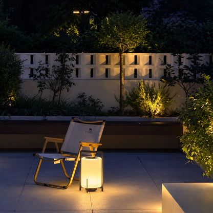 Lucciola rechargeable lantern lighting a garden seating area with a soft warm glow