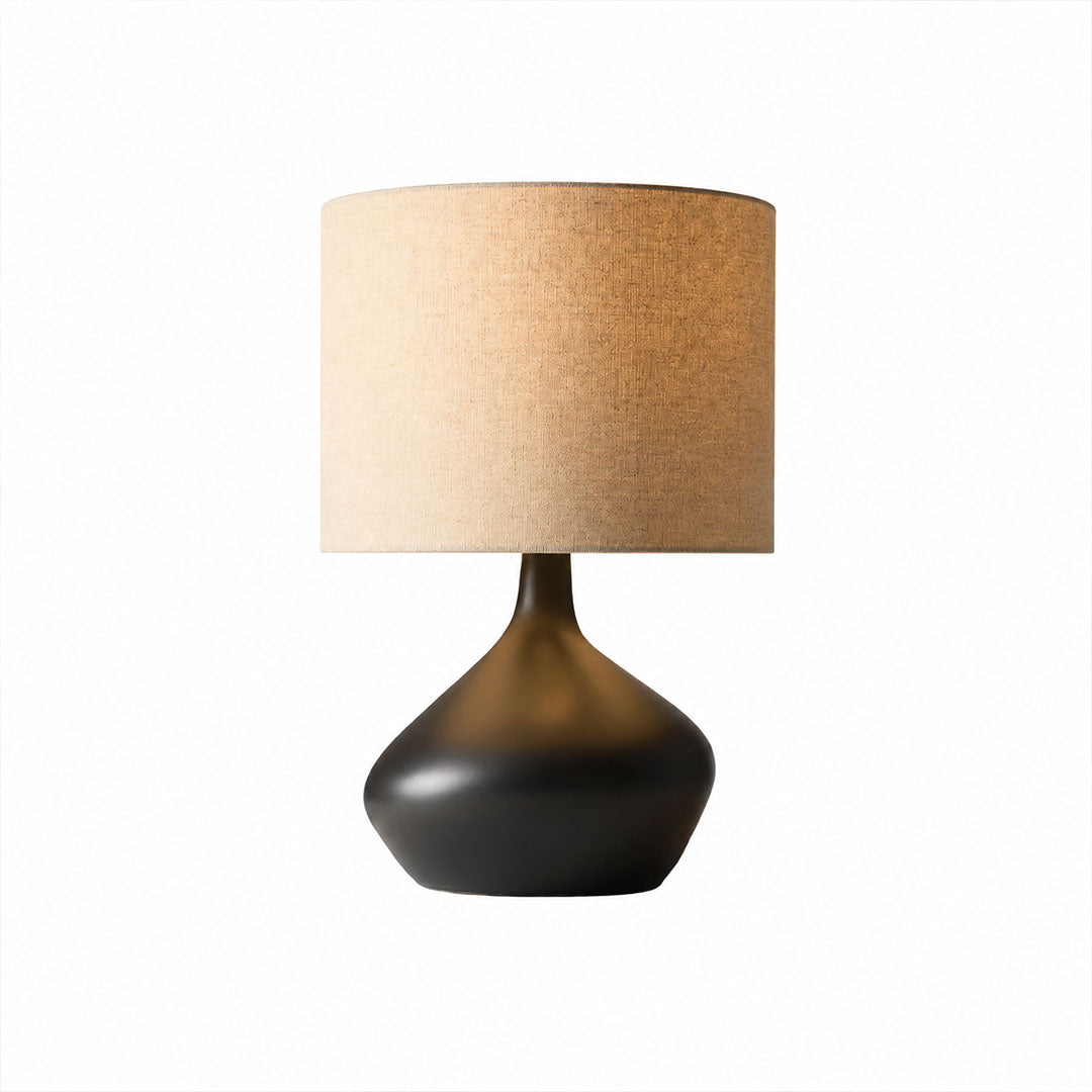 Terra ceramic table lamp illuminated warm inviting glow fabric shade ceramic base cozy white background