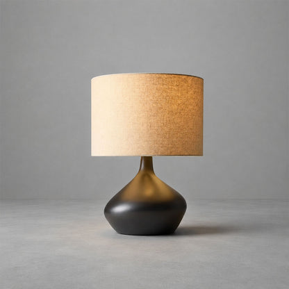 Terra ceramic table lamp illuminated warm inviting glow fabric shade ceramic base cozy white background
