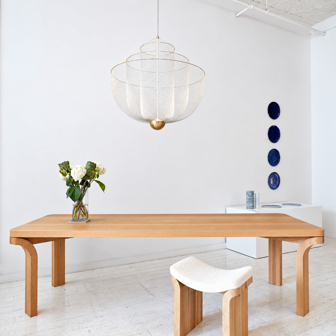 Meshmatics chandelier casting a warm glow over an elegant dining table