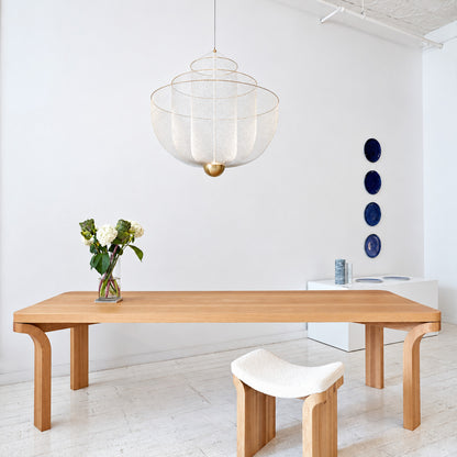 Meshmatics chandelier casting a warm glow over an elegant dining table