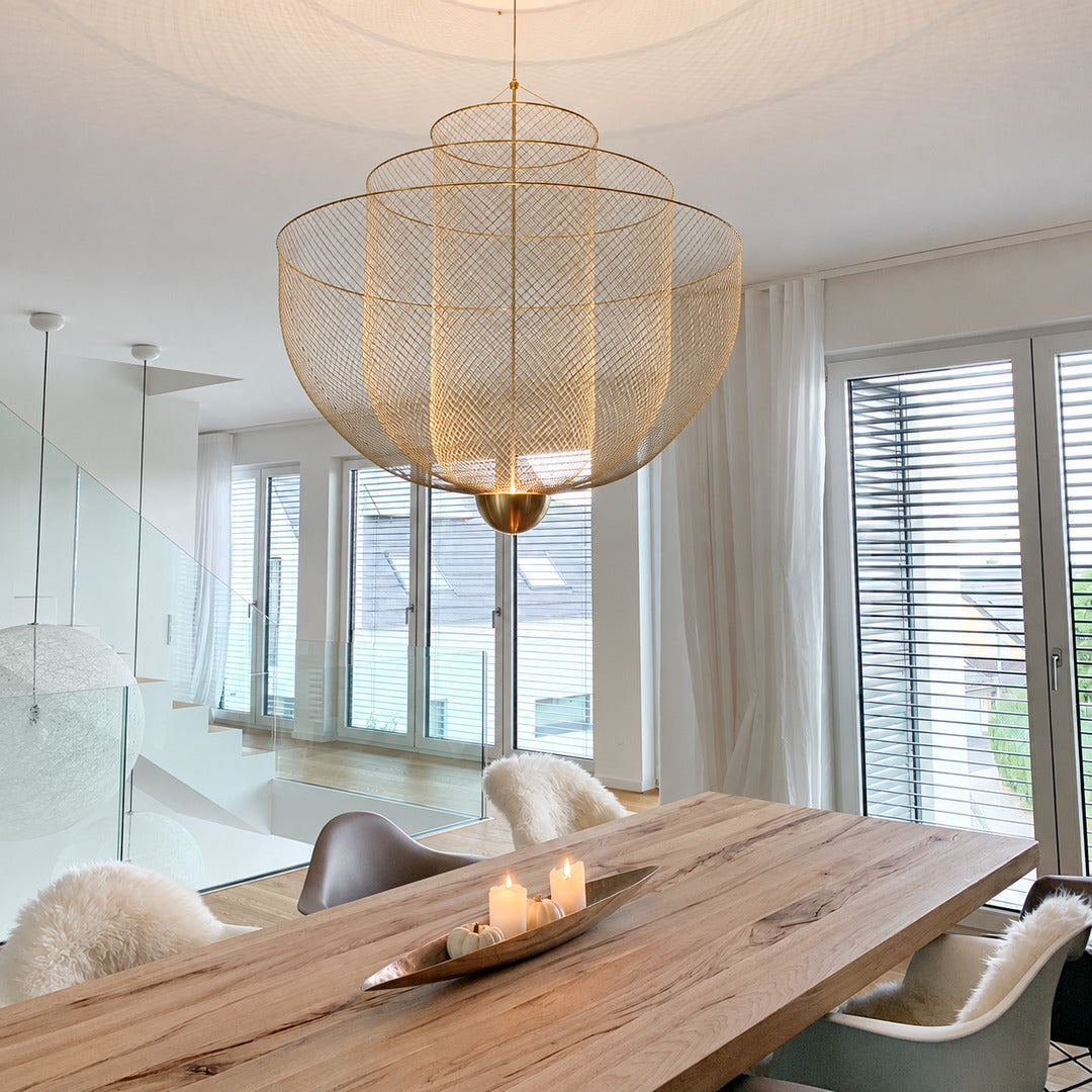 Meshmatics chandelier casting a warm glow over an elegant dining table