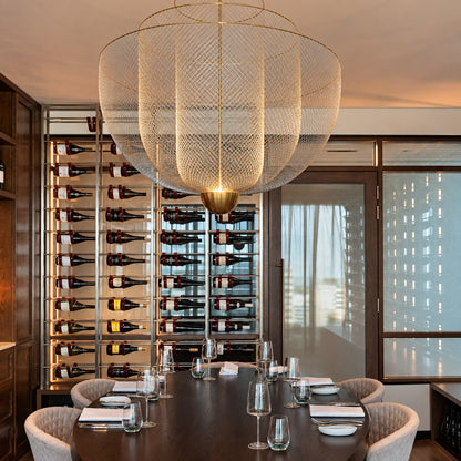 Meshmatics chandelier casting a warm glow over an elegant dining table