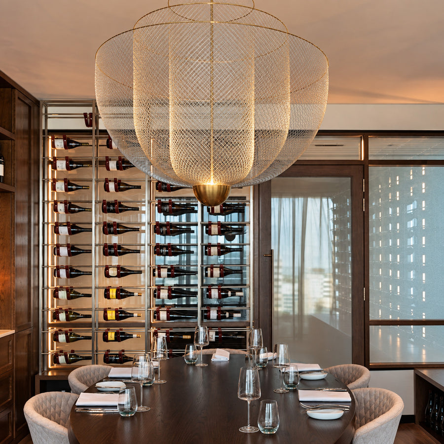 Meshmatics chandelier casting a warm glow over an elegant dining table