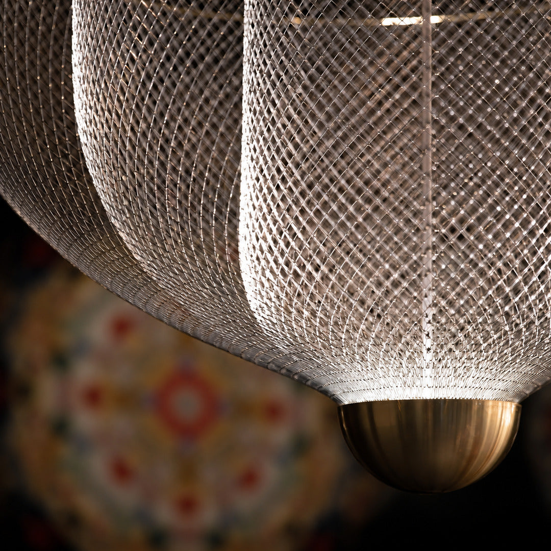Warm light filtering through the layered metal mesh of the Meshmatics chandelier