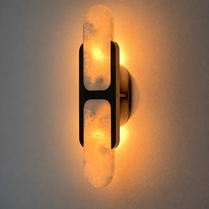 Warm light washing up and down the wall from the alabaster shade of the Mezzaluna sconce