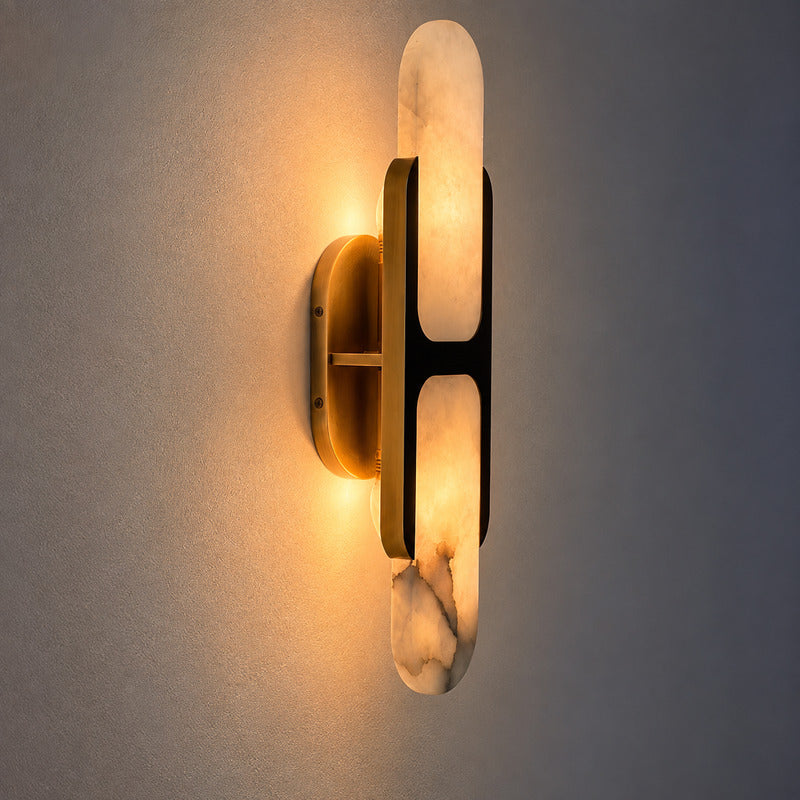 Warm light washing up and down the wall from the alabaster shade of the Mezzaluna sconce