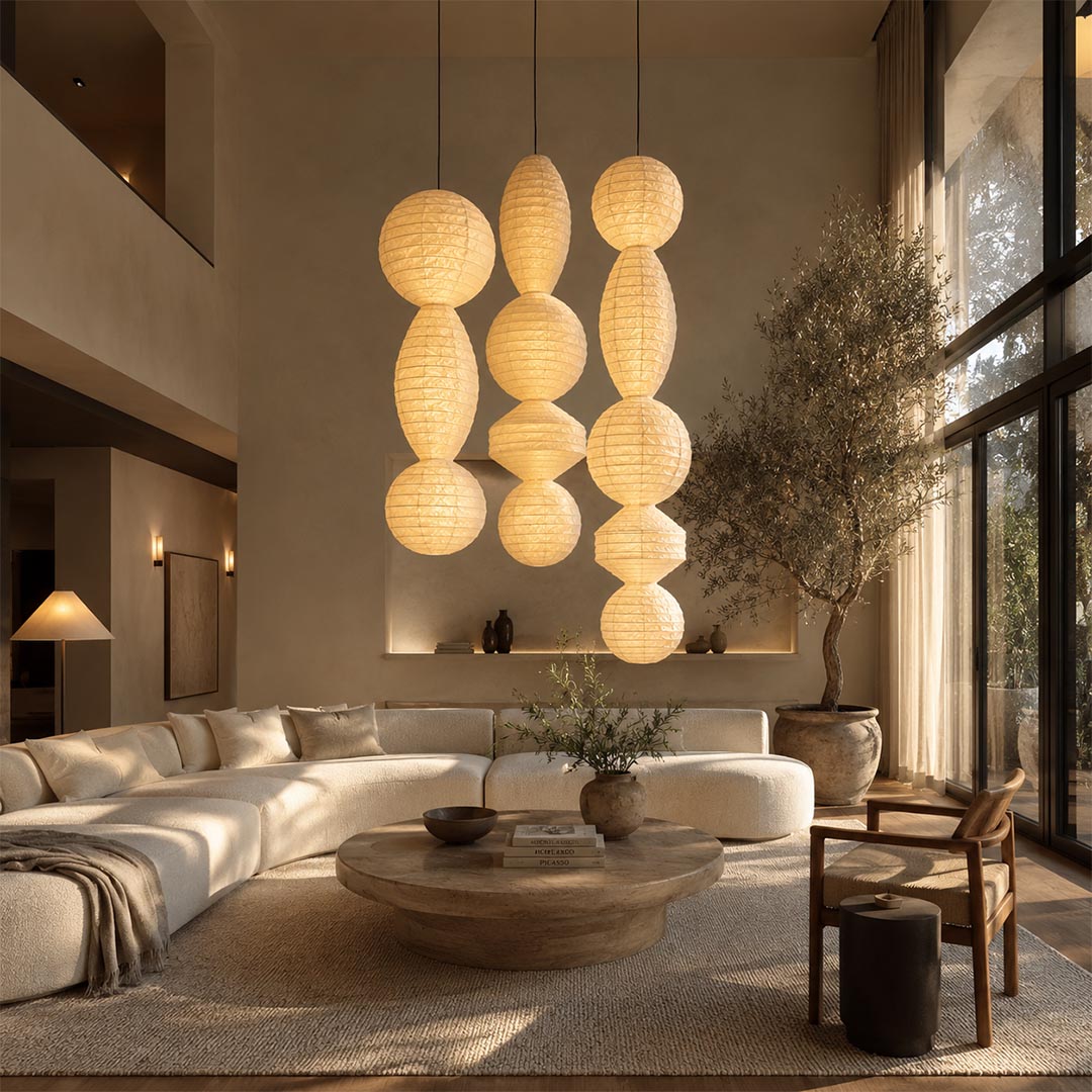 A cluster of three varied Ori Lantern Series Pendant Lights suspended in a spacious minimalist living room by Stuber Lighting.