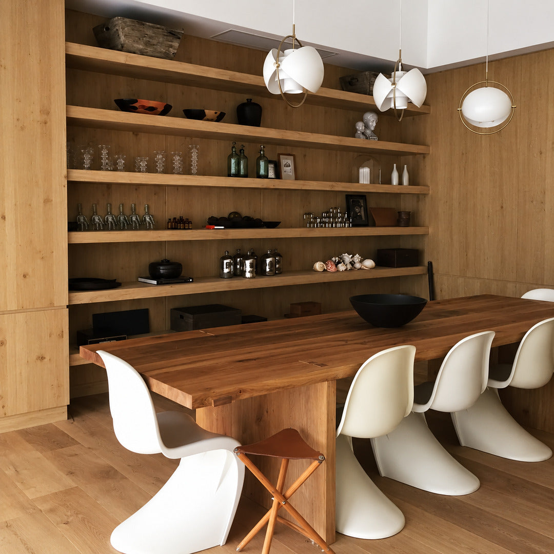 Emisfero pendant light casting adjustable warm light over a contemporary dining table