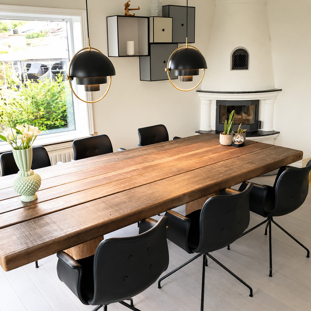 Emisfero pendant light casting adjustable warm light over a contemporary dining table