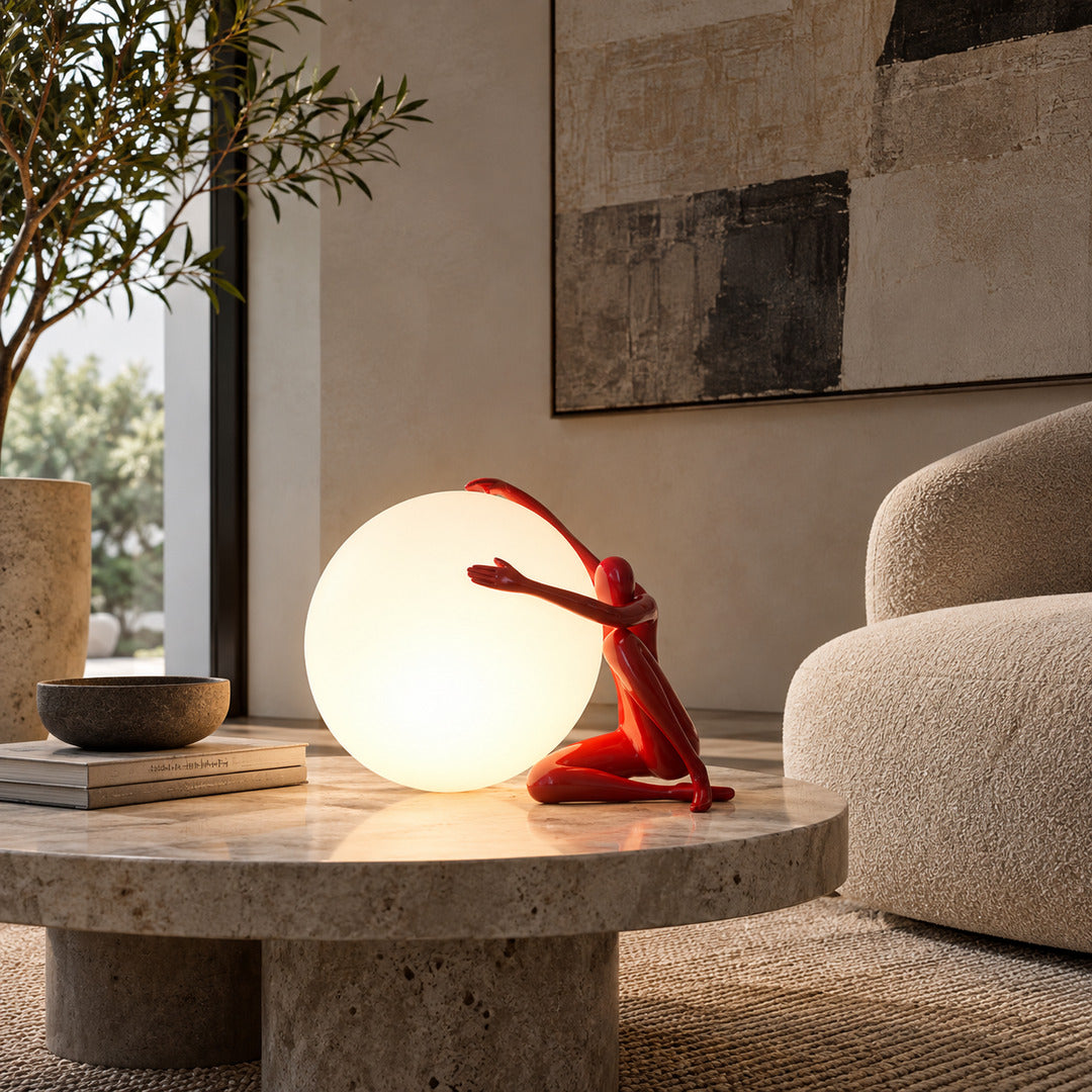 Musa sculpture table lamp casting a warm glow on a living room side table