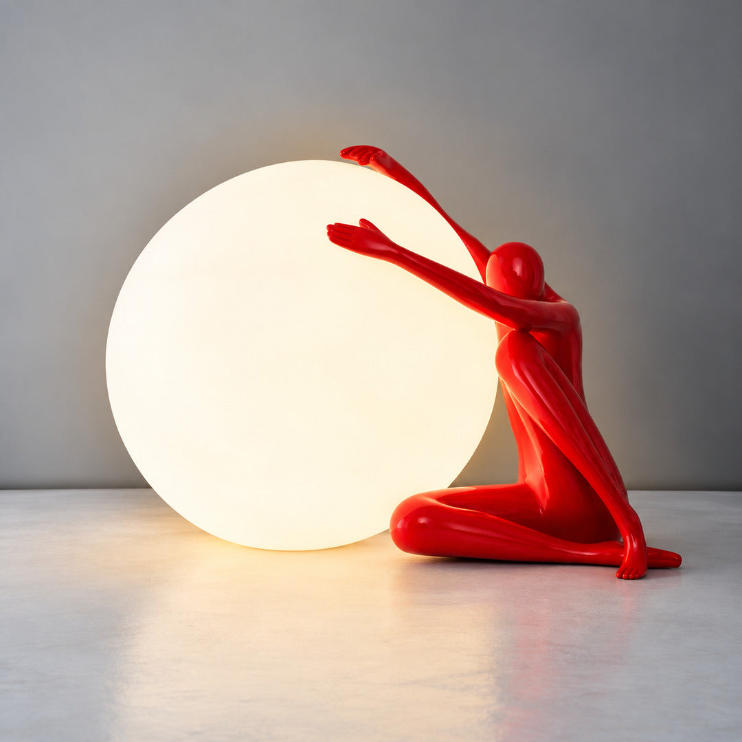Small red Musa sculpture table lamp adding a bold pop of color to a bedside table