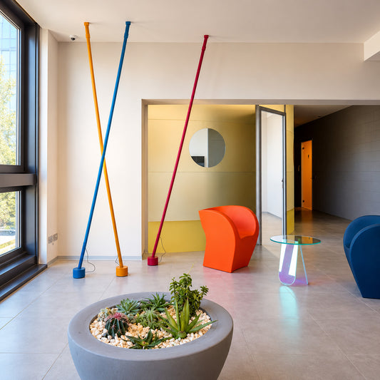 Three Nastro floor to ceiling lamps in red, yellow and blue grouped in a living room corner