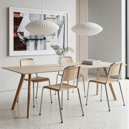 Nelson style bubble Cigar drum pendant pair above modern kitchen island Mid Century white spun polymer architectural warm glow interior