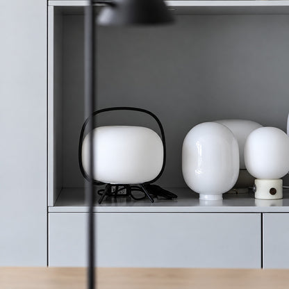 Nomade glass table lamp welcoming guests on an entryway console with a warm glow
