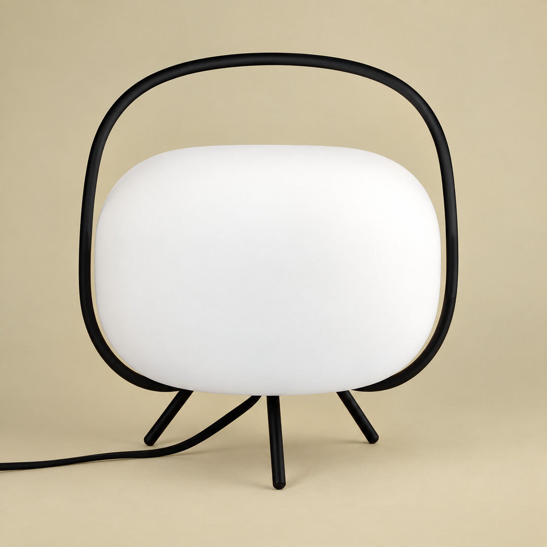 Black and white Nomade frosted glass lantern table lamp on a side table