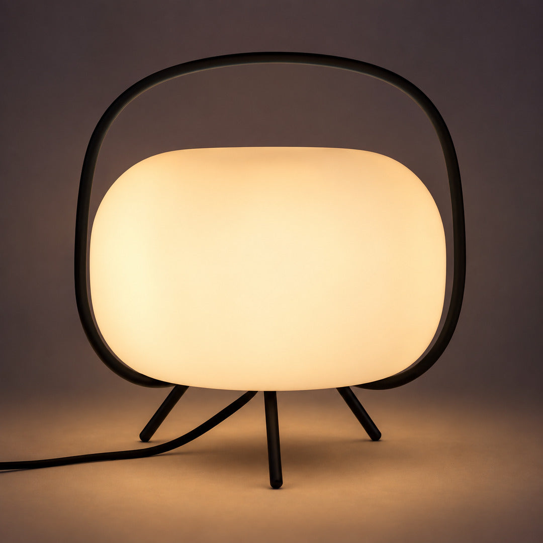 Soft warm glow diffusing evenly through the frosted glass shade of the Nomade table lamp