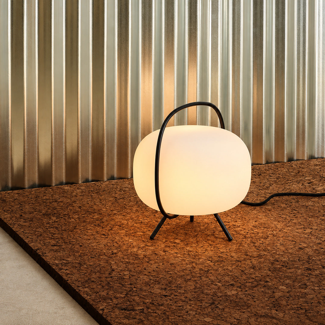 Nomade glass table lamp complementing a clean Scandinavian minimalist bedroom