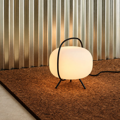 Nomade glass table lamp complementing a clean Scandinavian minimalist bedroom